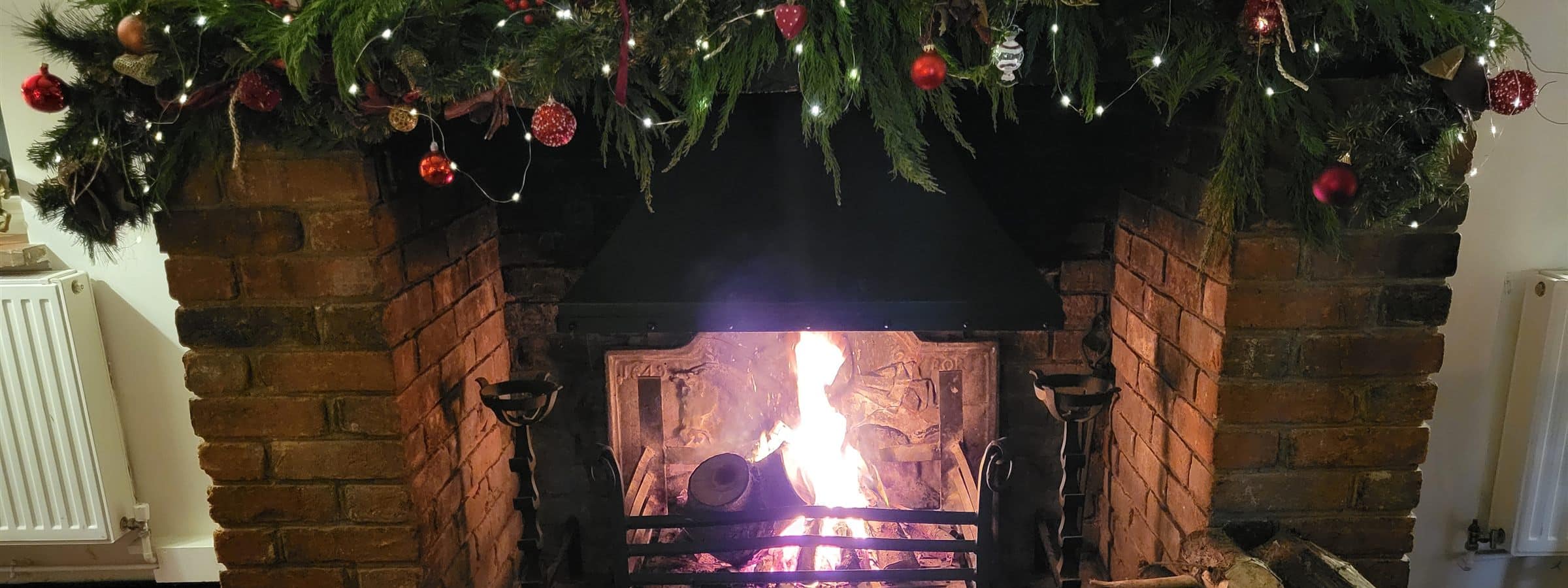 Log fire and Christmas garland at The Peacock Country Inn